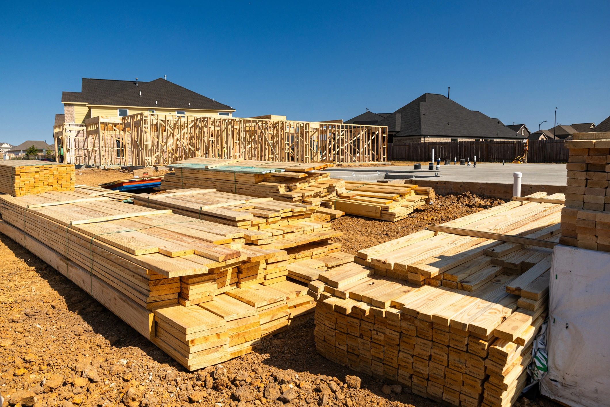 Construction framing materials beside a new concrete foundation in Texas